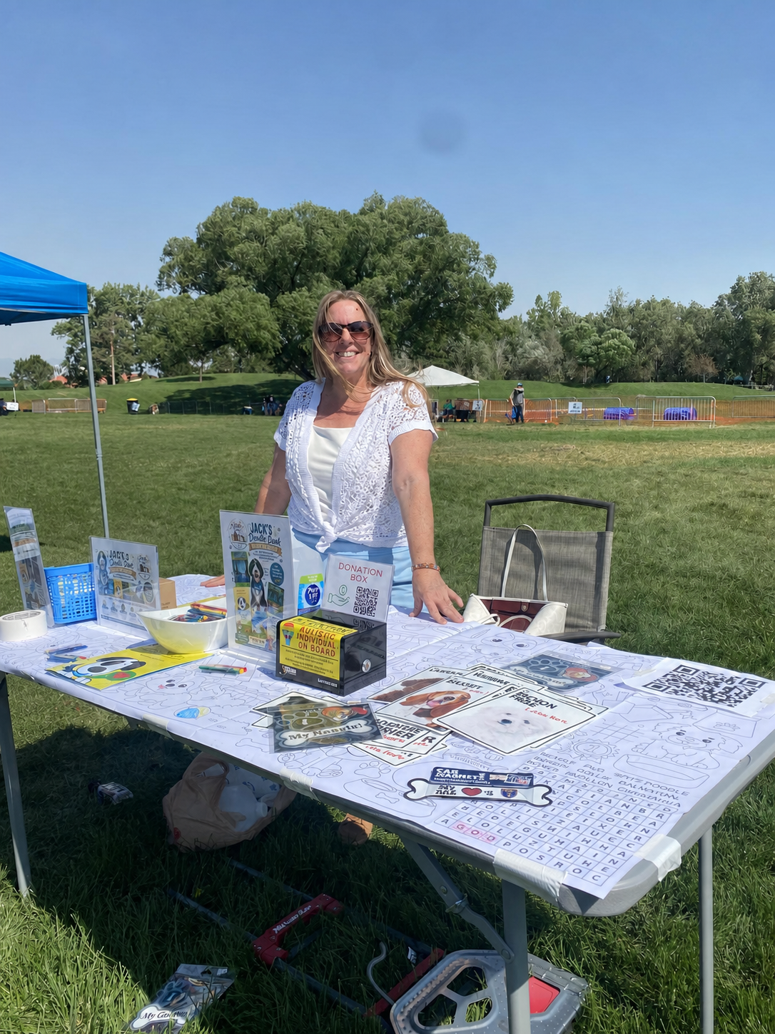 Sara Bradford at a community outreach table with books, safety resources, and activities